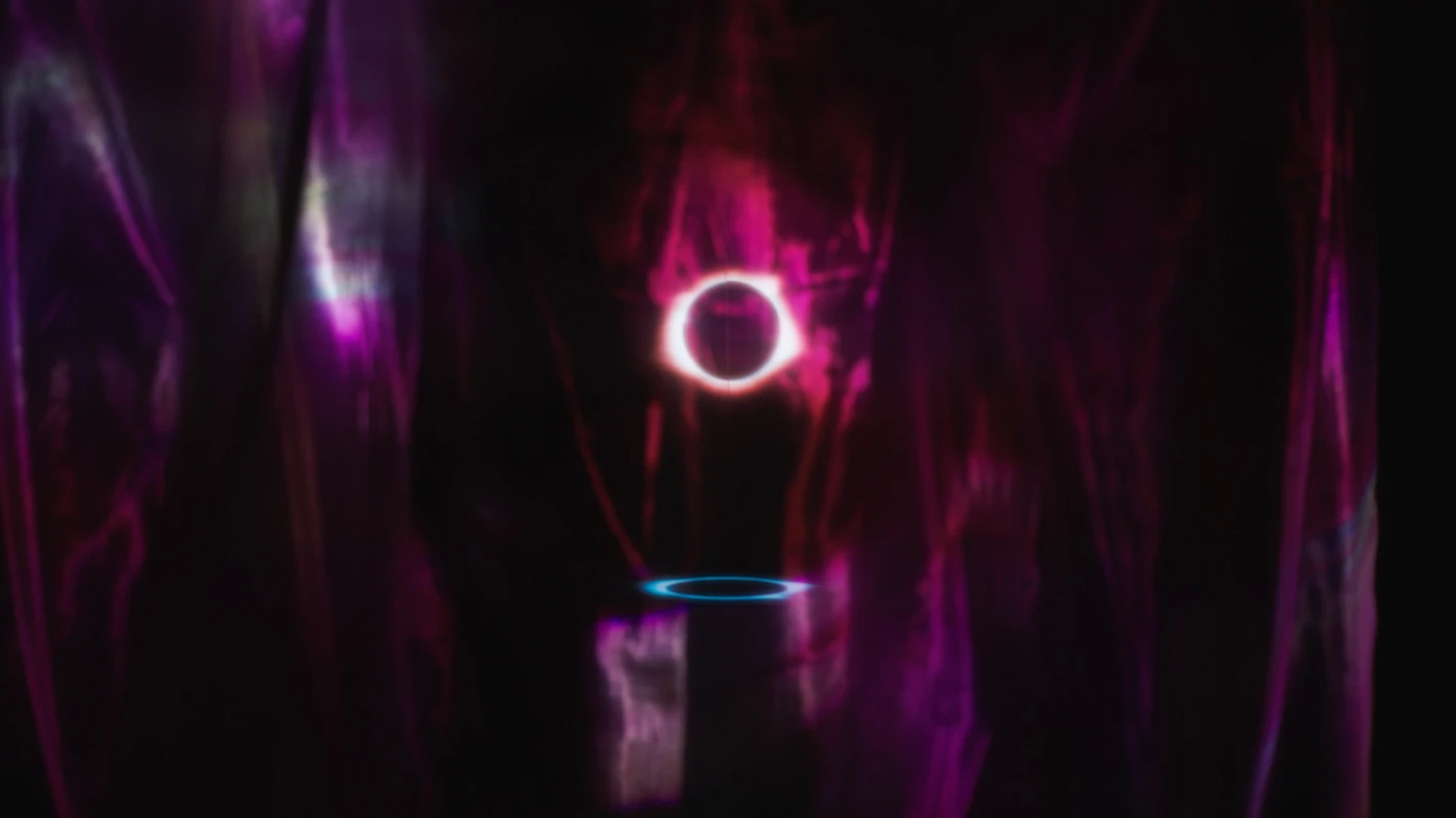 Installation with circular light structures under purple lighting.