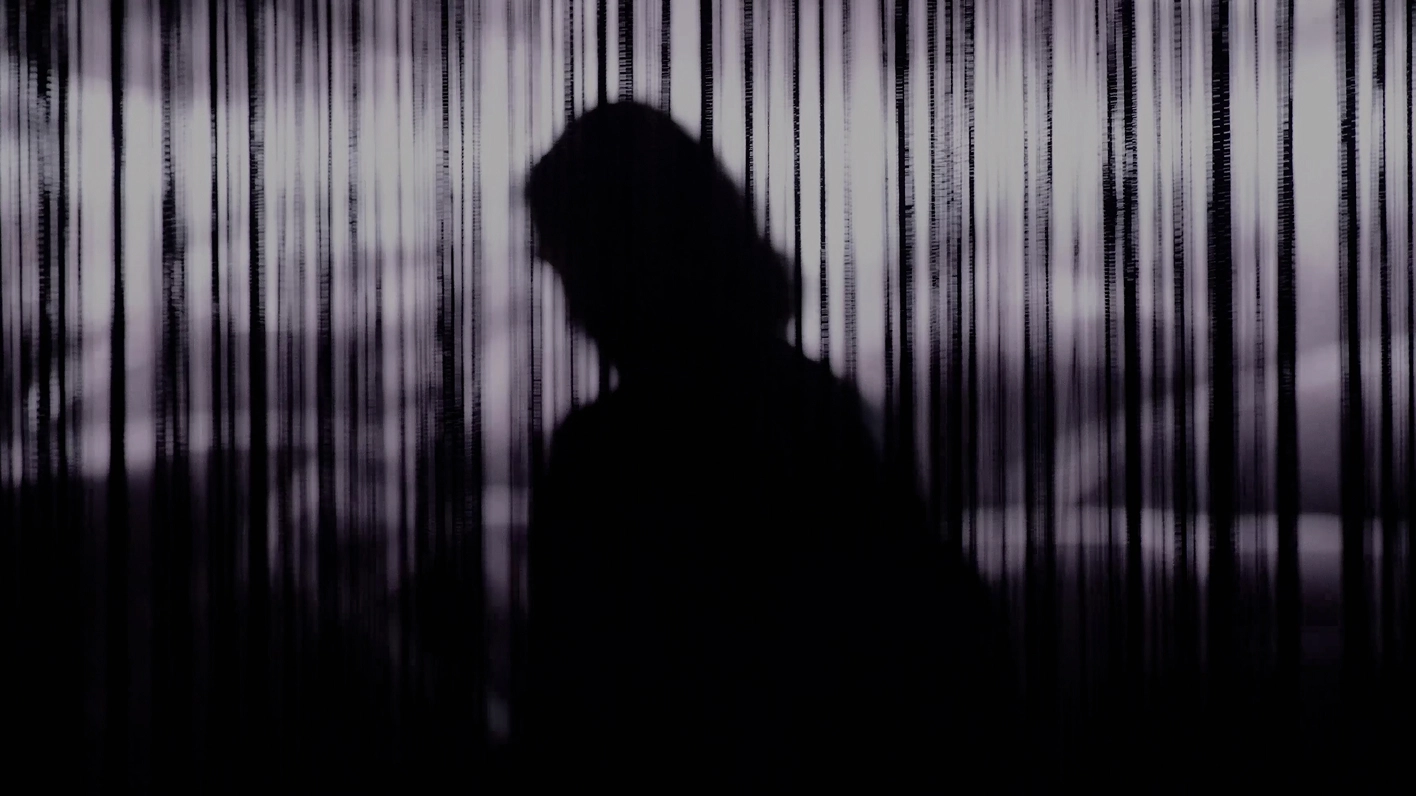 Human silhouette standing in front of vertical light beams.