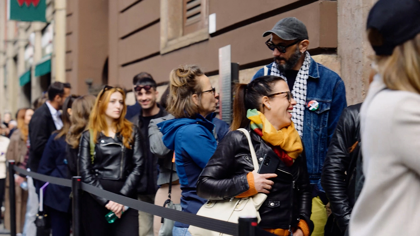 Visitors standing in line in an outdoor space.