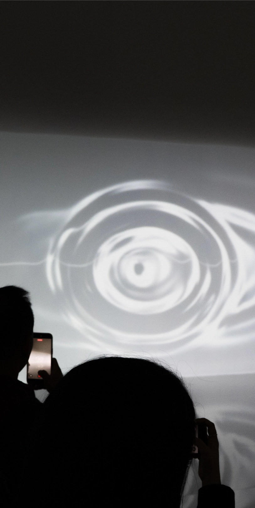 Visitors viewing projected waves of light in the Transition Space