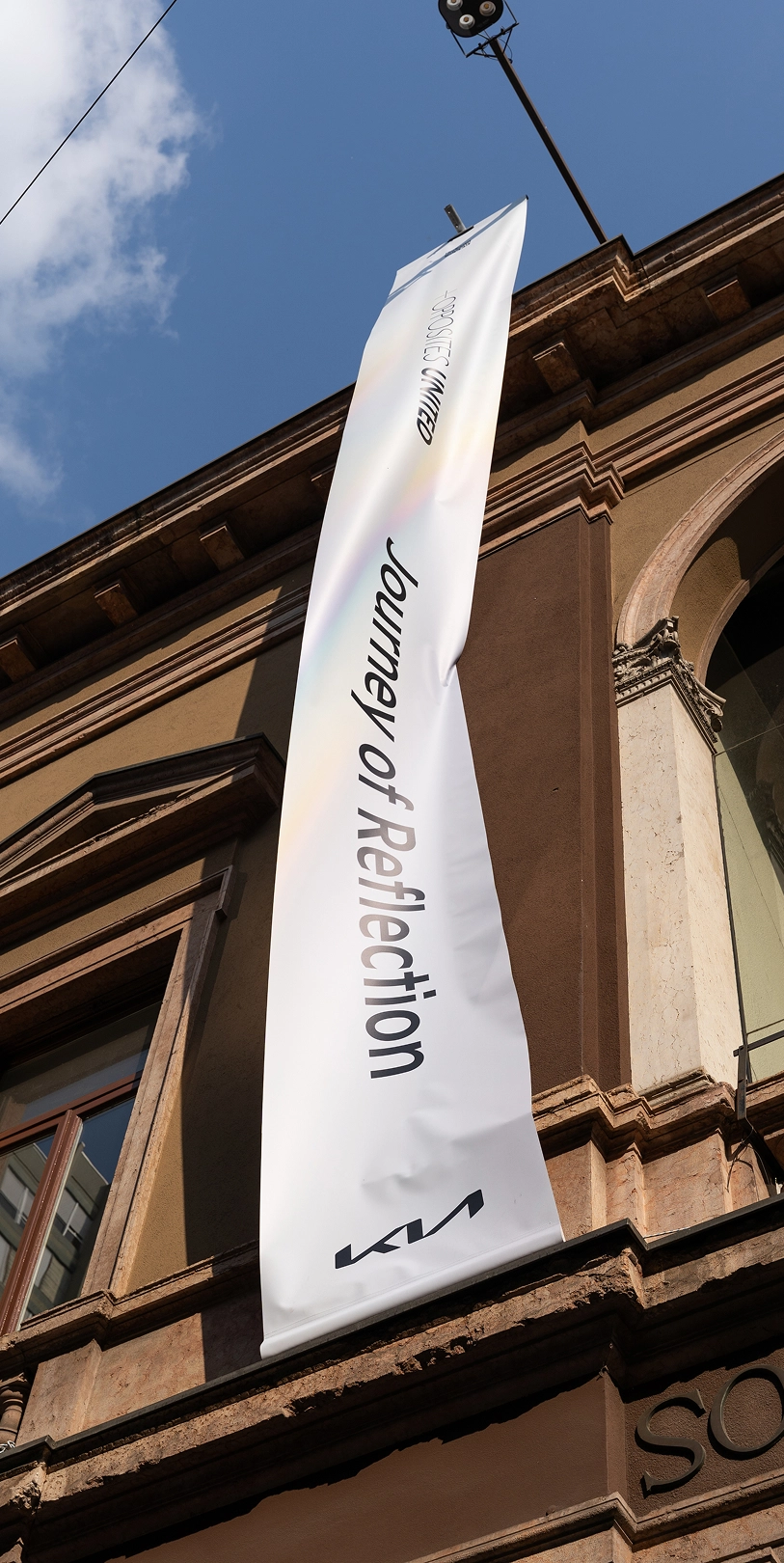 Exterior of Museo della Permanente hosting the Journey of Reflection exhibition with an OPPOSITES UNITED banner.