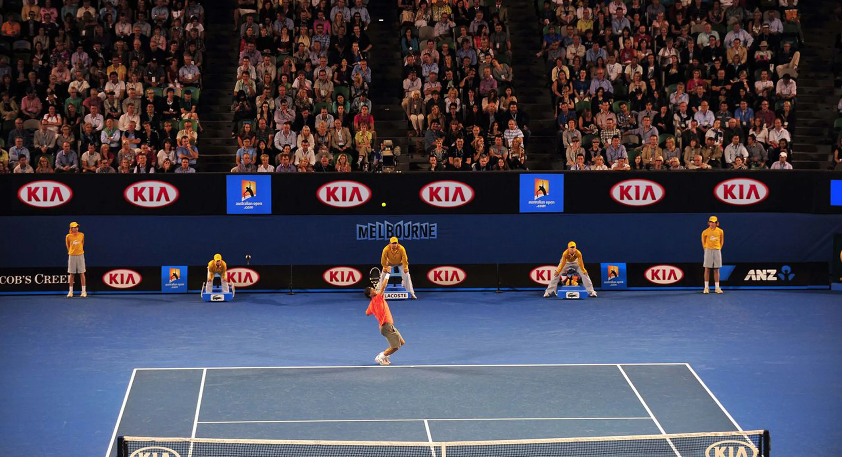 Rafael Nadal serving on a tennis court.