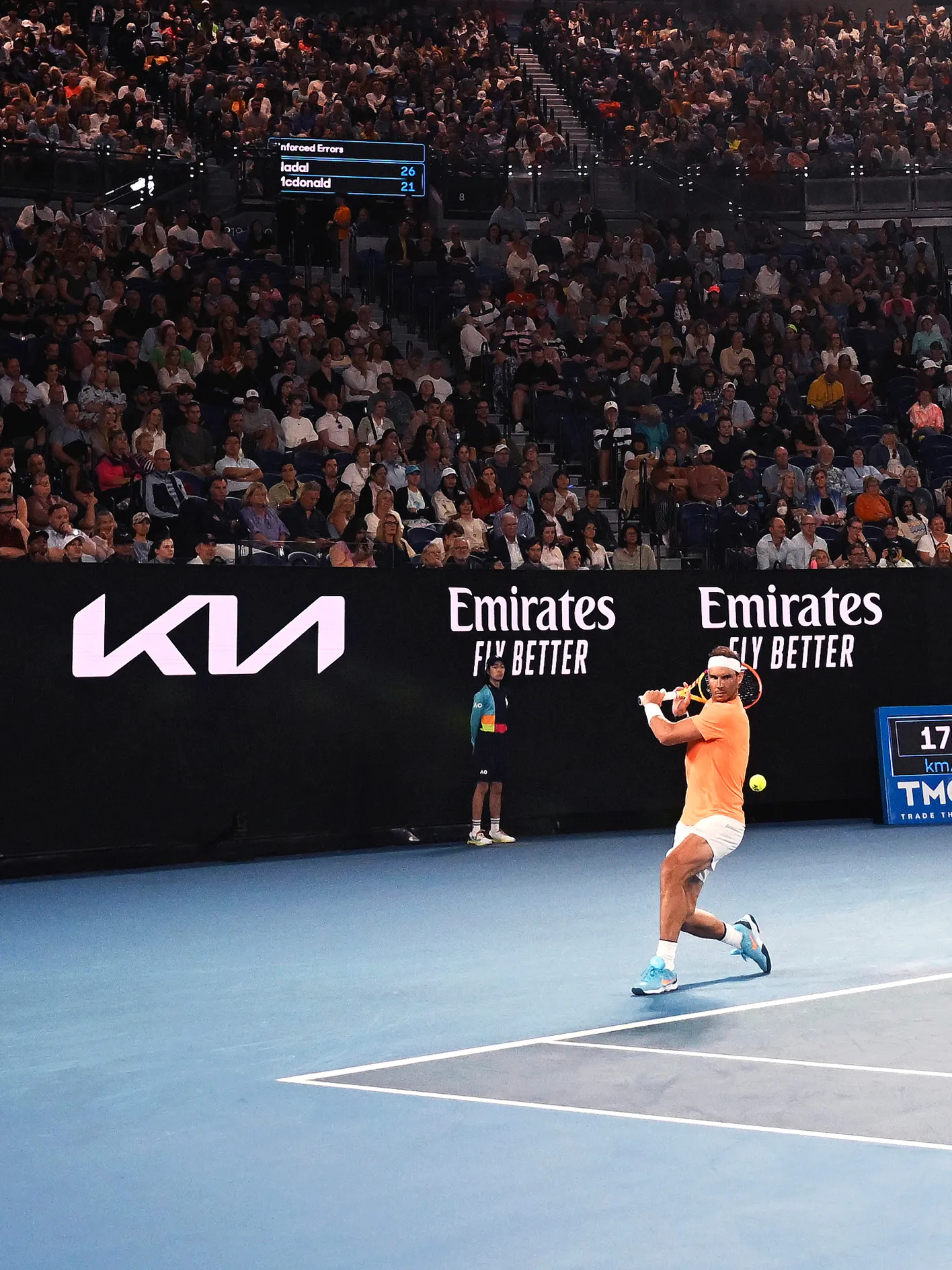 Tennis player competing on a court featuring Kia branding