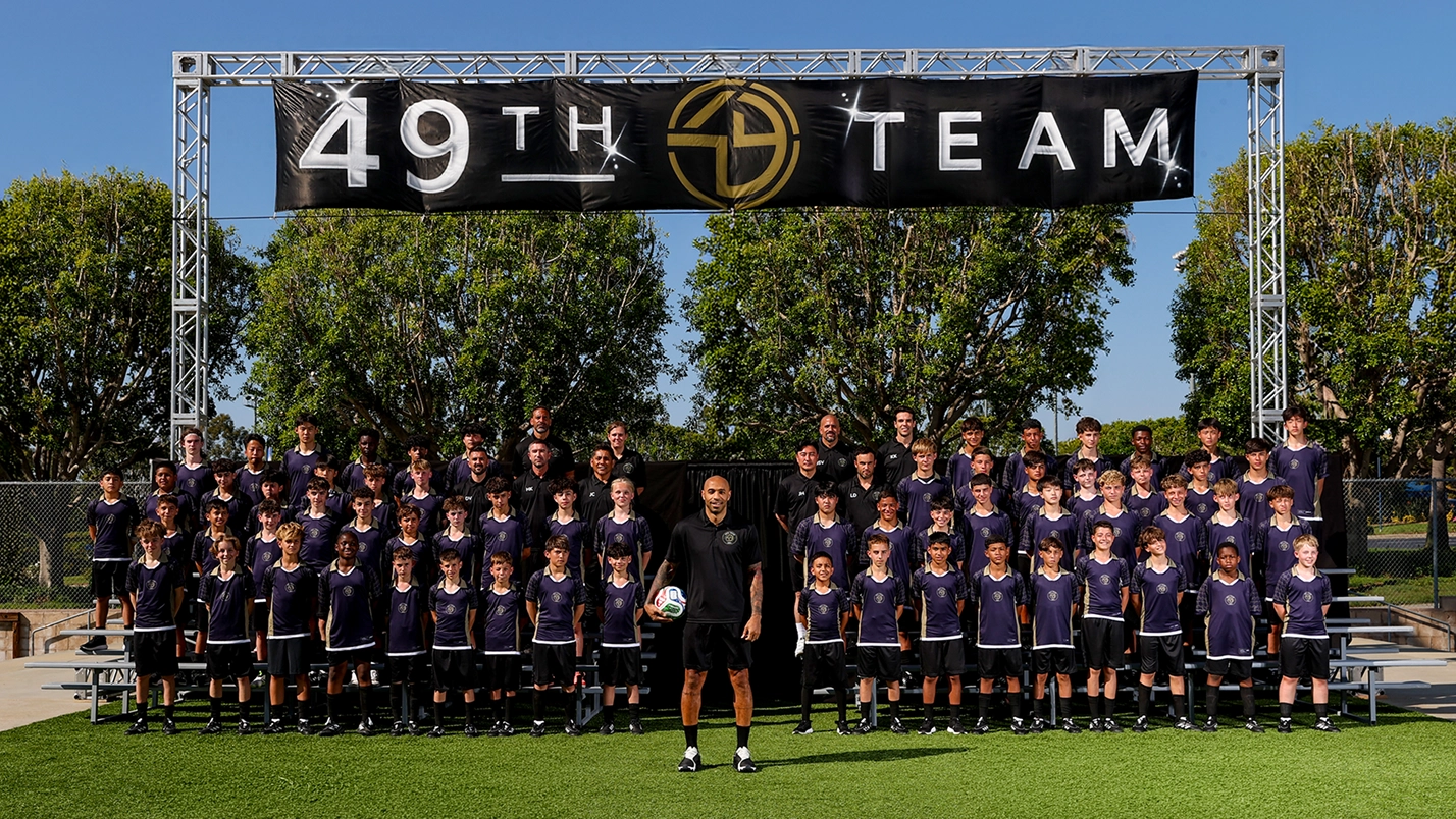 49TH TEAM' 문구가 적힌 구조물 아래 남색 유니폼을 입은 OMBC 참가자들이 단체로 모여 있는 49th Team 단체 이미지