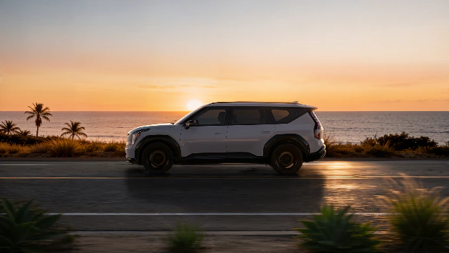 노을진 해안도로를 달리는 기아 SUV 이미지