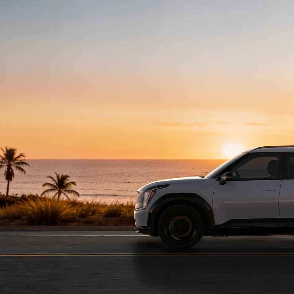 노을진 해안도로를 달리는 기아 SUV 이미지