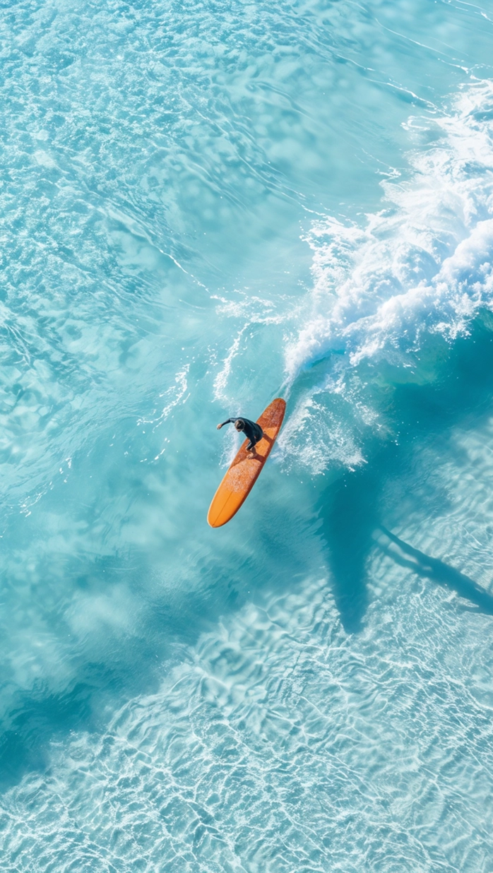Aerial image of a surfer riding a wave in the ocean