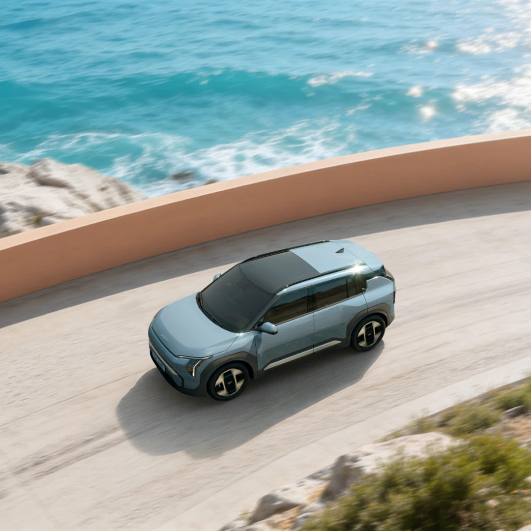A Kia vehicle driving along a coastal road