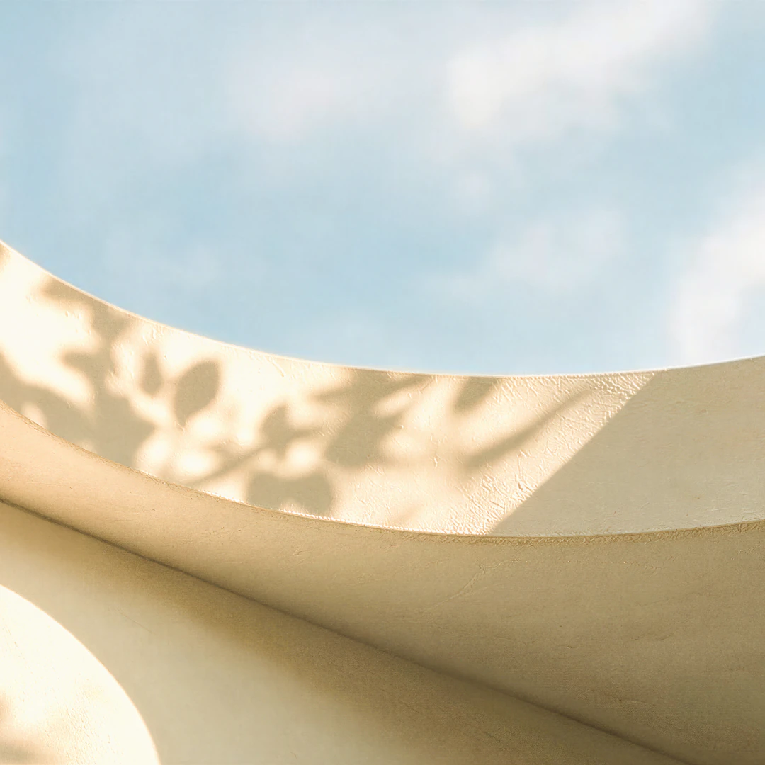 Sunlit curved architecture framing a blue sky