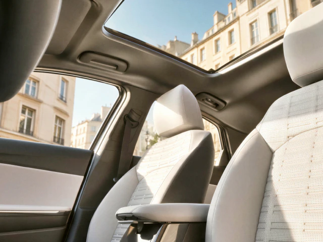 Interior image of a Kia vehicle featuring a panoramic sunroof and light-colored seats