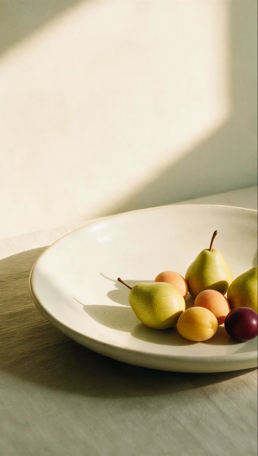 Fruit arranged on a plate on a sunlit table