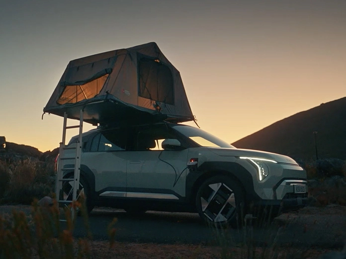 Image of the Kia EV3 with a rooftop tent at a campsite, winner of the 2024 TopGear.com Crossover of the Year