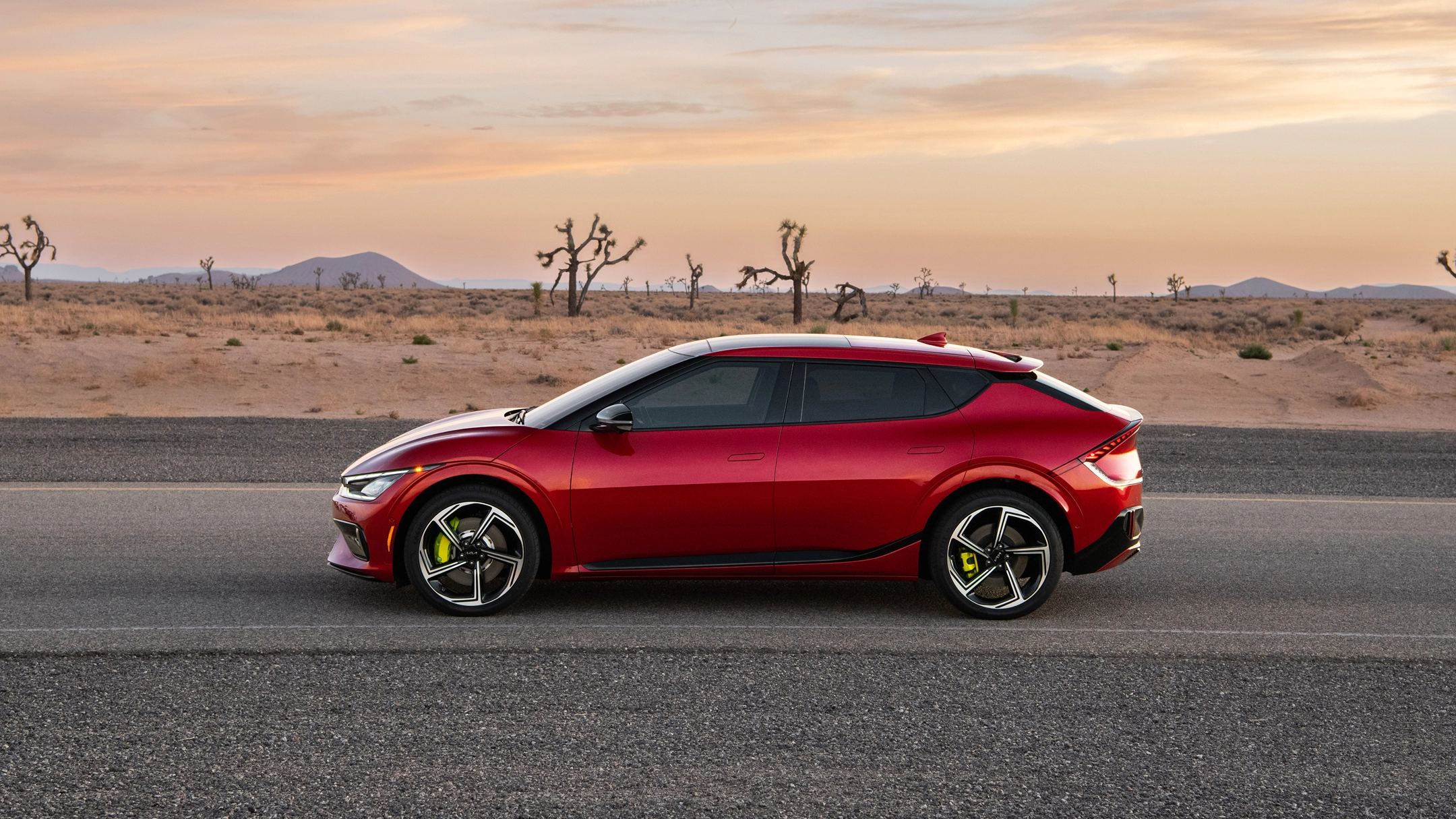 Side view of the Kia EV6 driving on a desert road
