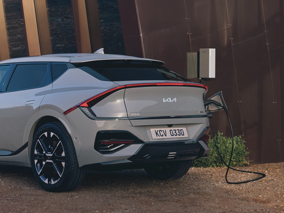 Rear view of the Kia EV6 charging in front of a building