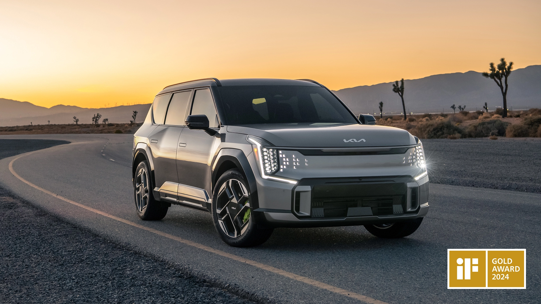 Front view of the Kia EV9 driving on a road at sunset