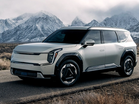 Front and side view of the Kia EV9 parked with snow-covered mountains in the background