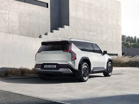 Rear view of the Kia EV9 parked in front of a architectural space