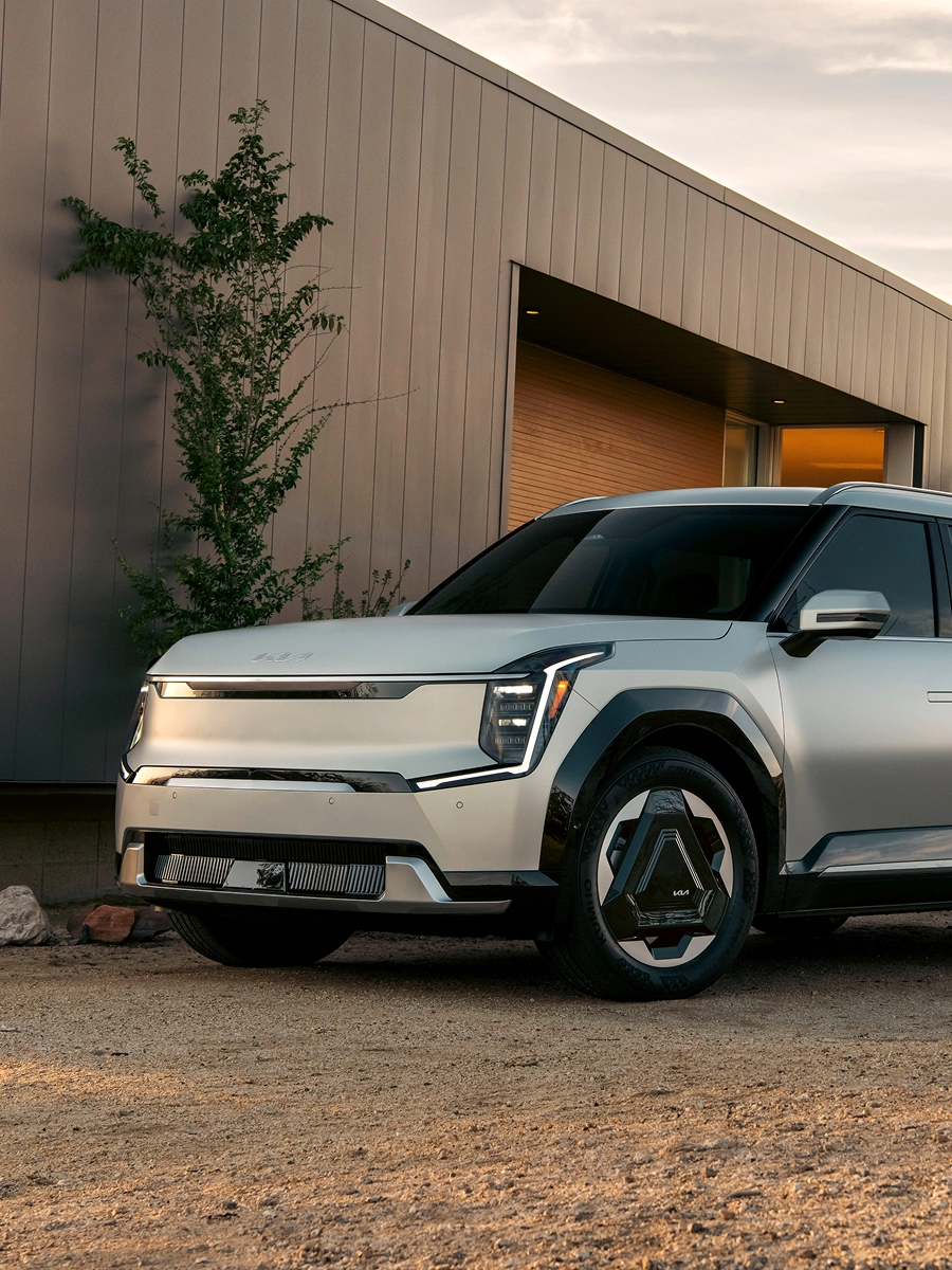 Exterior image of the Kia EV9 parked in front of a house