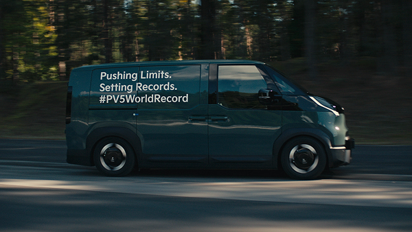 The Kia PV5 Cargo driving along a forest road