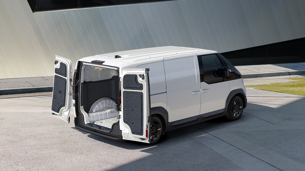 The rear doors of the Kia PV5 Cargo open, revealing the cargo space