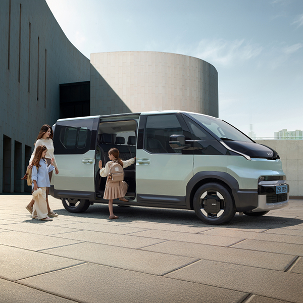 A family boarding the Kia PV5 Passenger through the sliding door