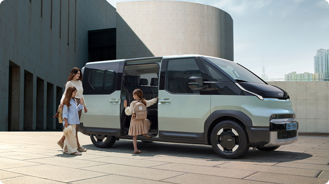 A family boarding the Kia PV5 Passenger through the sliding door