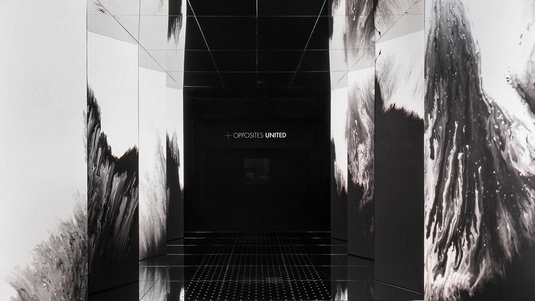 Entrance media wall in black and white with a mirrored floor of 'Passage of Footsteps'.