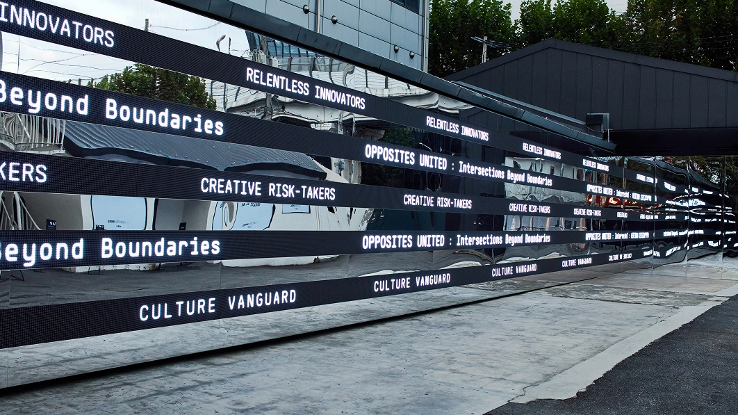 Media strips along the building exterior displaying repeated 'OPPOSITES UNITED' typography at the Seongsu solo exhibition in Seoul.