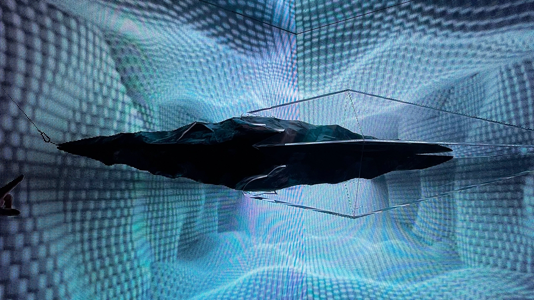 Installation with a floating black abstract structure within a digital grid at the DDP solo exhibition.