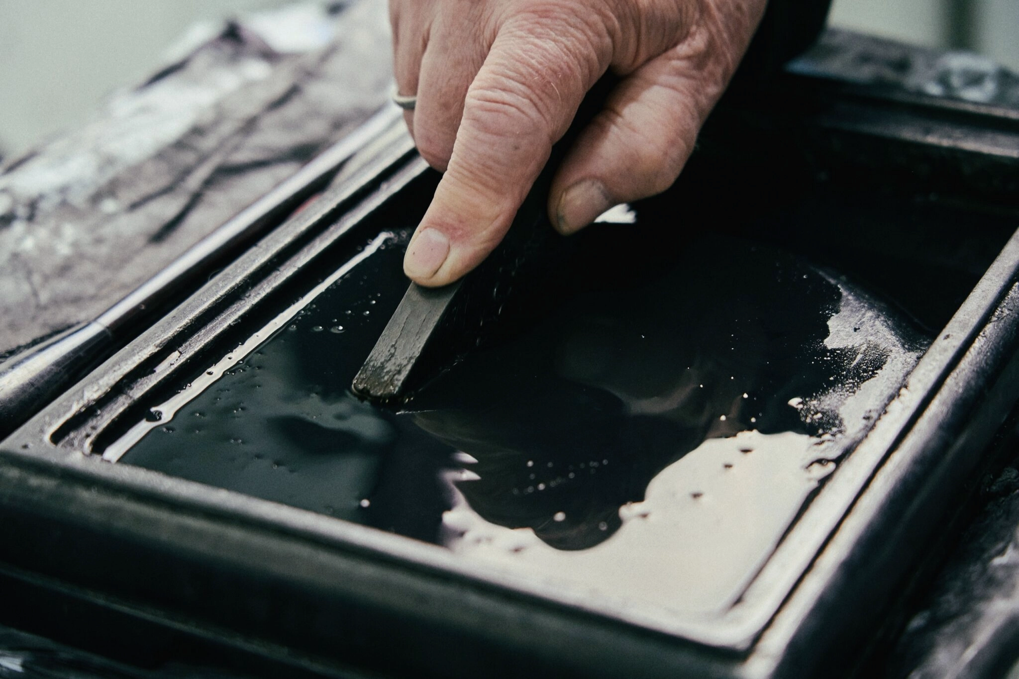 A close-up of hands working with a black material