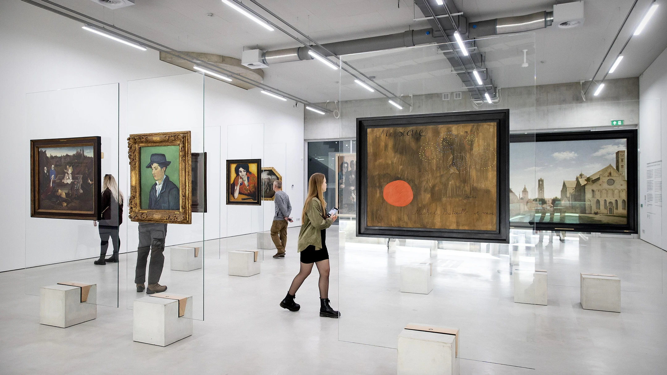 미술관 전시 공간에서 작품을 관람하는 방문객 이미지