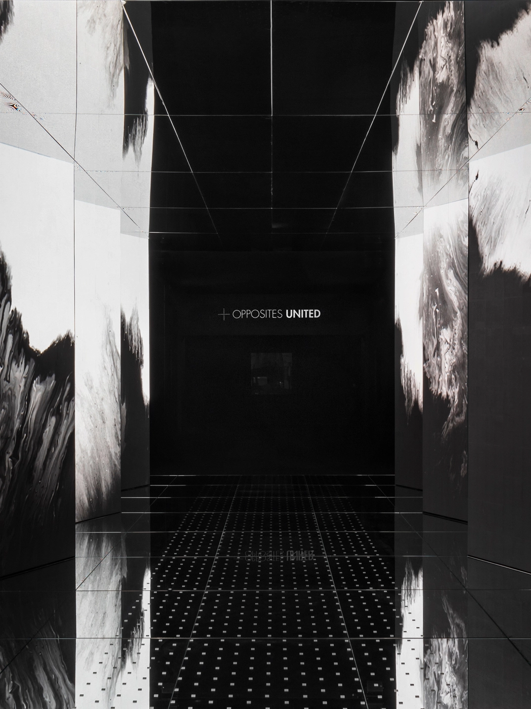 전시장 입구의 흑백 미디어 월과 반사되는 거울 바닥의 작품 'Passage of Footsteps' 모습