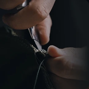 가위로 섬유를 자르는 손의 클로즈업 모습