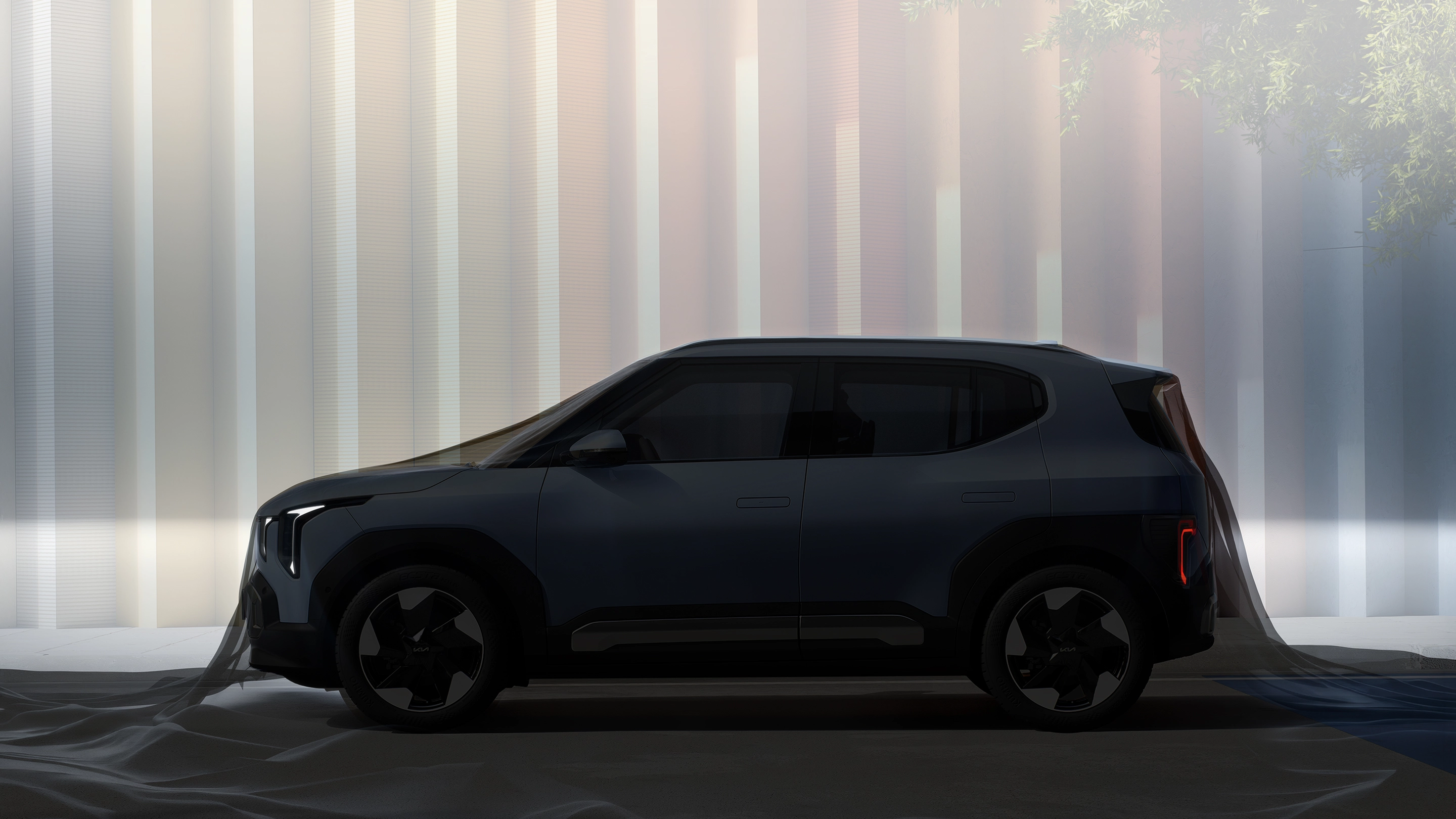 Side view image of Kia EV2 parked in front of urban architecture