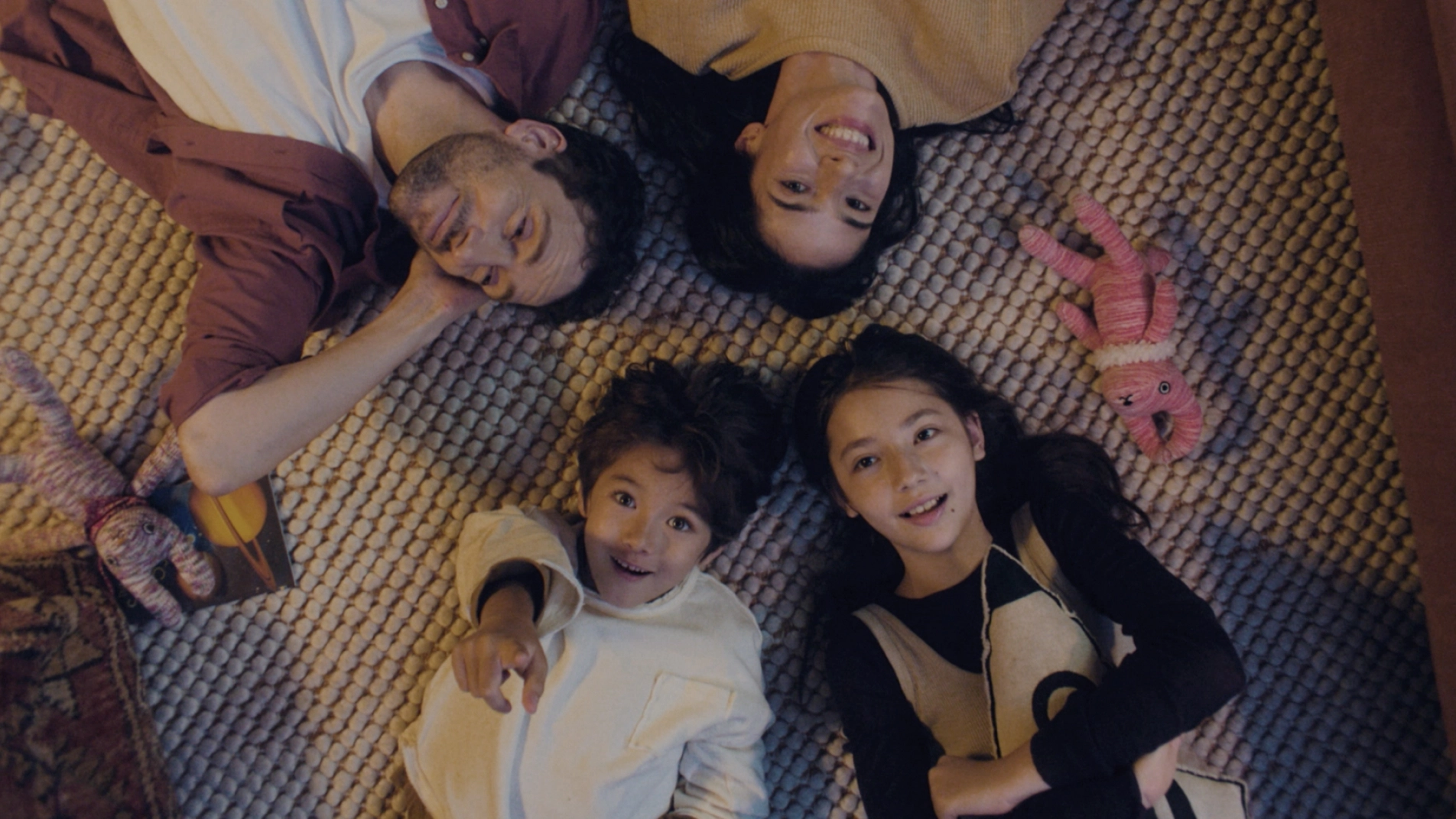 A family relaxing inside the EV5 on the flat space created by the folded 2nd-row seats.