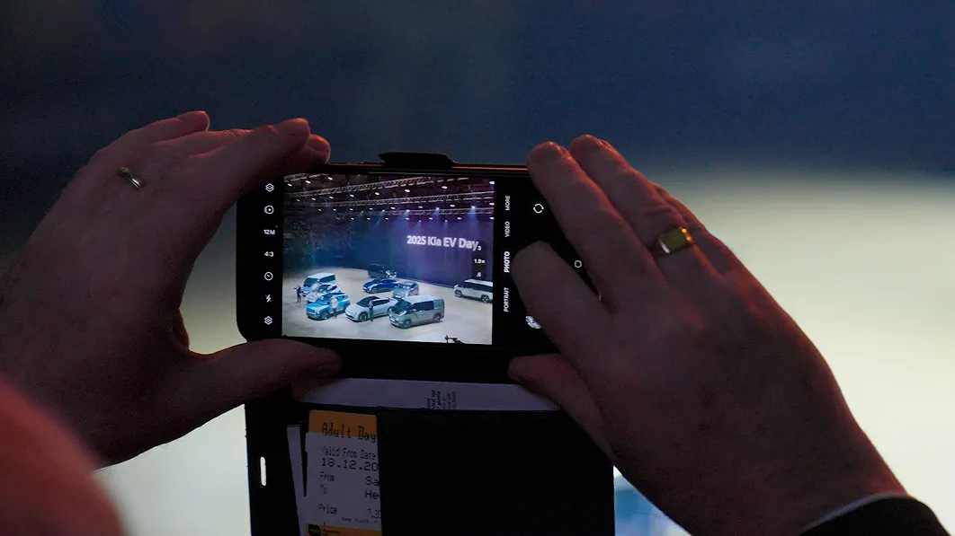 관람객이 스마트폰으로 EV Day 전시 차량을 촬영하는 모습 이미지