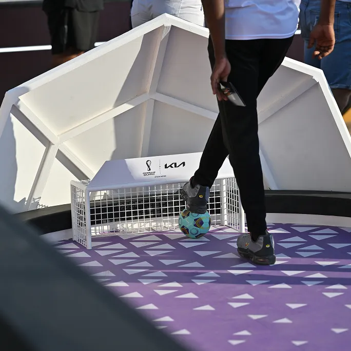 Visitor participating in a mini football game at a Kia experience booth