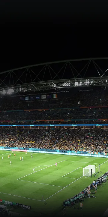 Panoramic view of a football stadium under night lights filled with spectators