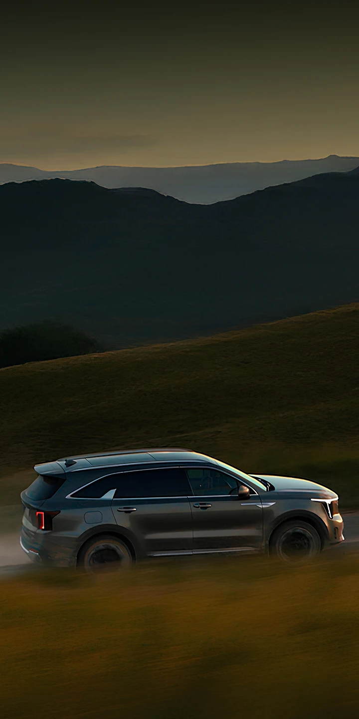 자연 풍경 속을 주행하는 기아 SUV 차량 이미지