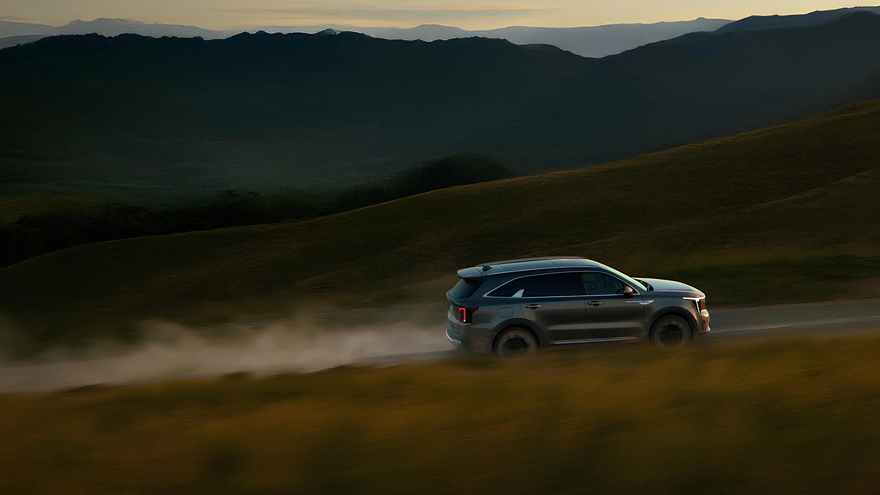 자연 풍경 속을 주행하는 기아 SUV 차량 이미지