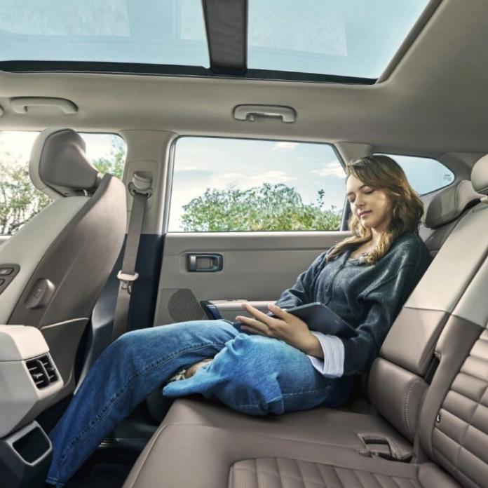 차량 실내 뒷좌석에 앉아 있는 탑승자 이미지