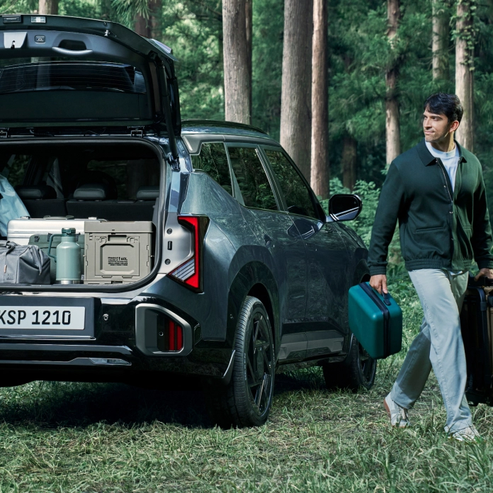 기아 SUV 차량 트렁크에서 짐을 꺼내는 장면 이미지