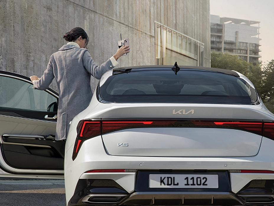 기아 차량 트렁크에서 짐을 내리는 장면 이미지