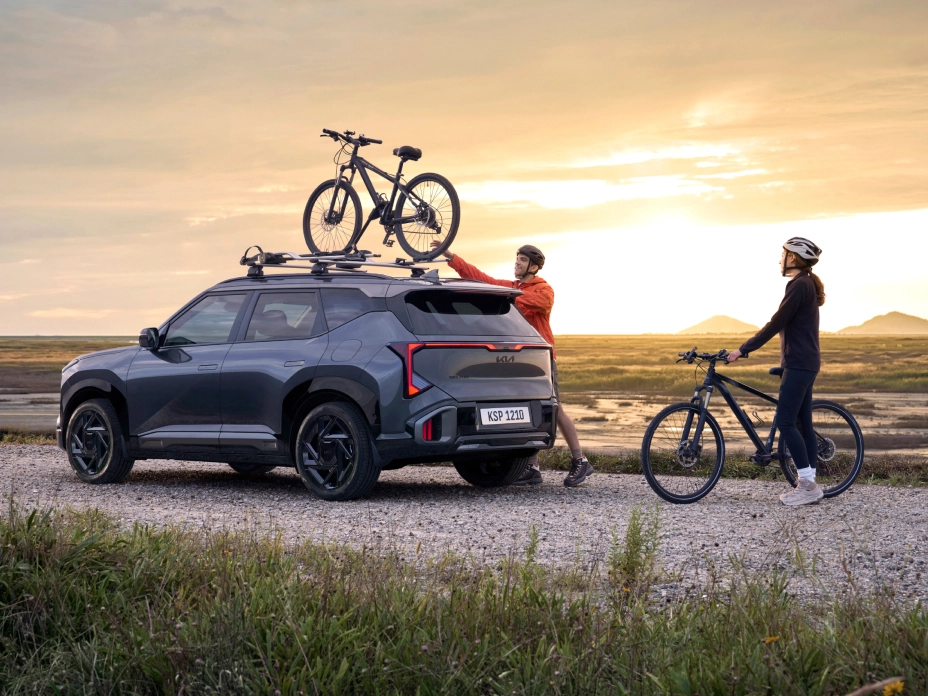 기아 SUV 차량  루프에 자전거를 장착한 레저 장면 이미지