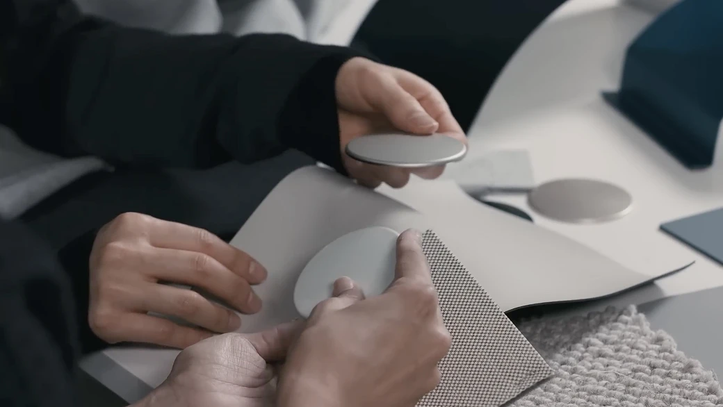 소재 샘플을 들고 대체 소재를 비교하는 사람들