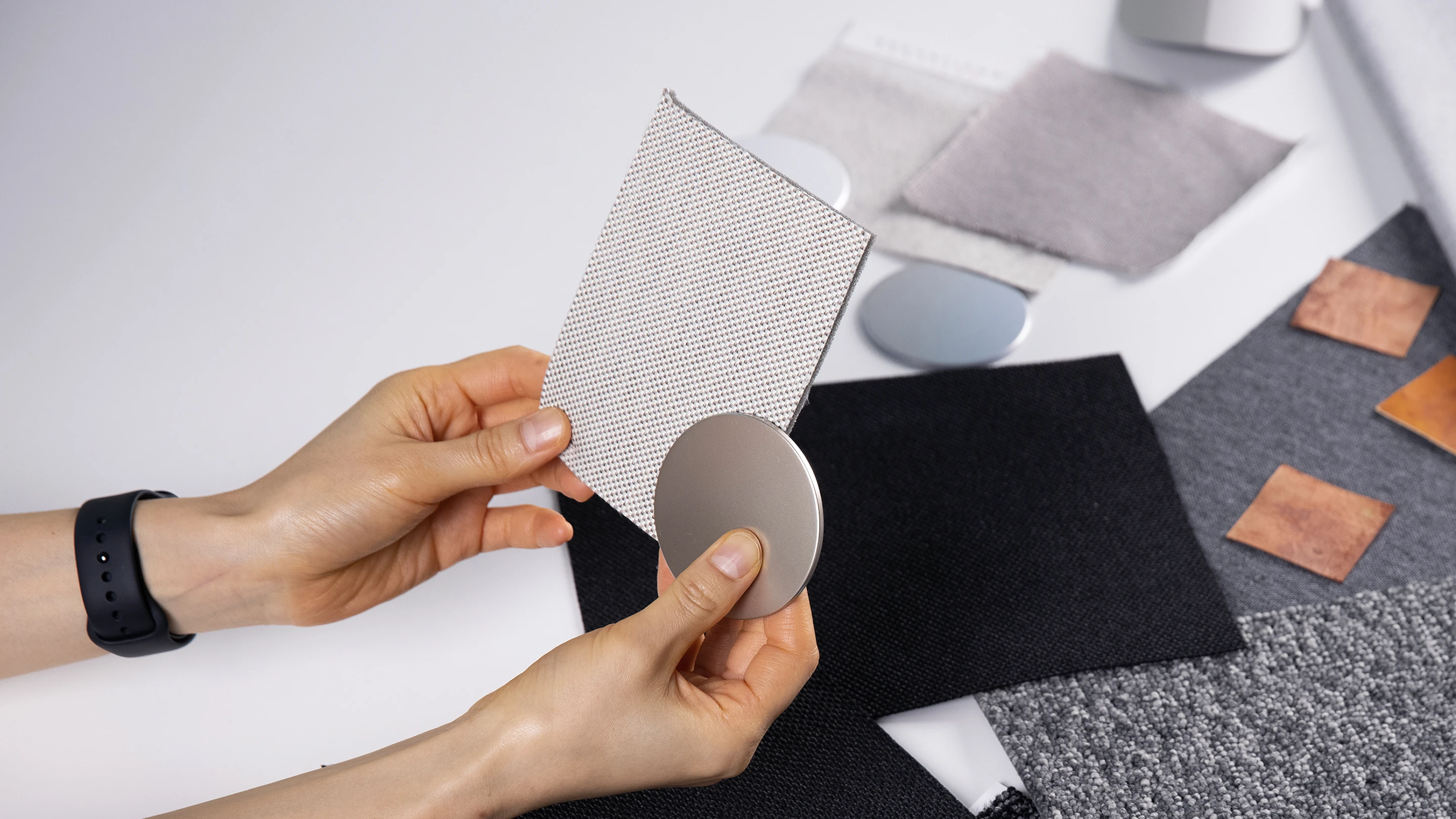 다양한 질감의 지속 가능한 소재 샘플을 손에 들고 비교하는 장면