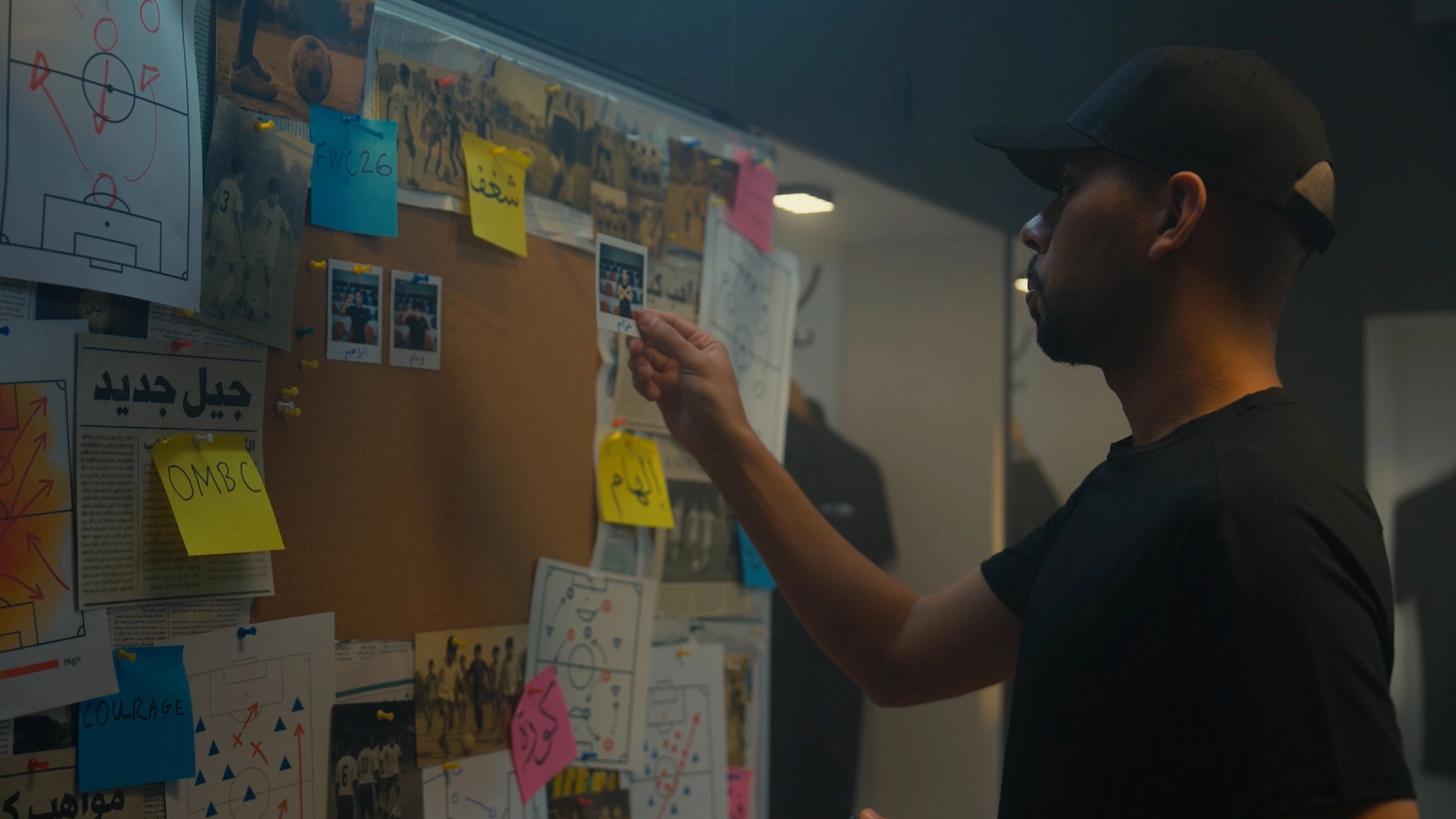 Football legend reviewing a participant recruitment board for the OMBC campaign