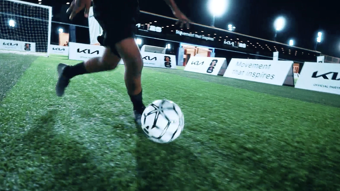 OMBC participant dribbling a football on the pitch