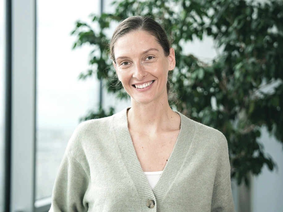 Kia Europe employee Evelin smiling during an interview by an office window
