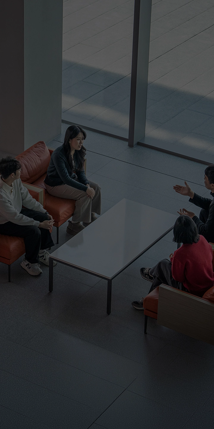 Kia employees sitting on facing sofas and talking freely in the headquarters lobby lounge